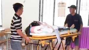 Nữ sinh nằm băng ca làm bài thi THPT, được xe cứu thương đưa đón