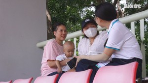 Ẵm con 18 tháng tuổi theo cổ vũ chồng thi đấu giải bóng đá công nhân