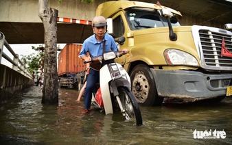 Ho Chi Minh City residents wade through flooded streets at rush hour as high tide hits again