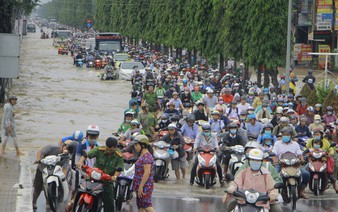 People wade through rising water on first day of week in Vietnam’s Mekong Delta city