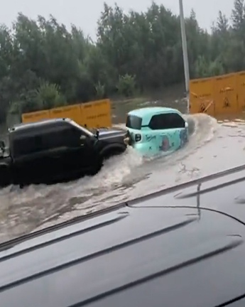 Ô tô xăng và ô tô điện dìu dắt nhau qua đường ngập