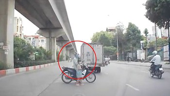Người đàn ông đi xe máy giúp bé gái sang đường an toàn