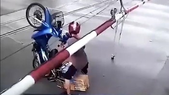 Xe máy chổng ngược lên trời vì cố vượt barie chắn tàu