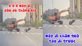 Máy xúc đang sang đường thì rơi bánh