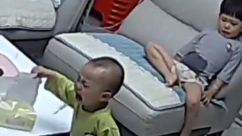 Em trai lấy khăn giấy chùi mũi xong rồi cầm lau mặt cho anh