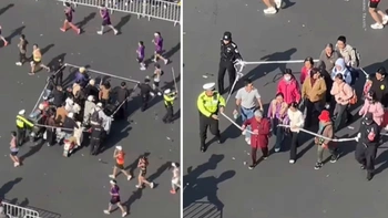 Nhân viên giải marathon căng dây dẫn khán giả qua đường đua