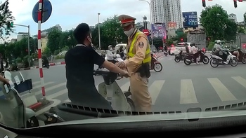 Thanh niên không đội mũ bảo hiểm chờ đèn đỏ bị cảnh sát giao thông tuýt còi