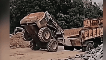 Máy xúc lên thùng xe tải phong cách 'trồng cây chuối'
