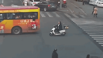 Bé gái treo lơ lửng ngoài cửa sổ xe buýt đang chạy, người đi xe máy lao tới cứu