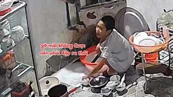 Bé trai dùng đá mài gõ để gỡ hai cái tô dính nhau