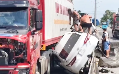 Ô tô bị ép vào dải phân cách sau va chạm với xe container, 3 người thoát chết