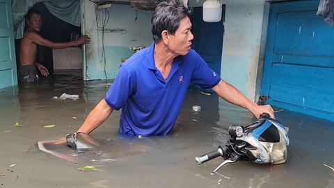 Người dân lội nước đẩy xe máy ngập lút yên ra khỏi nhà ở Thủ Đức