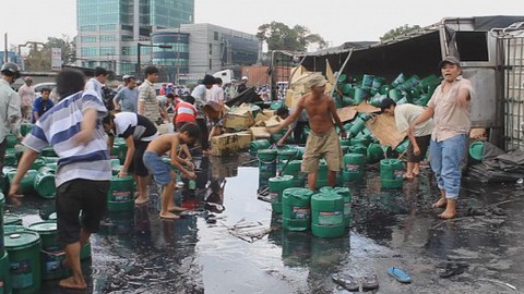 Dân đổ xô "hôi của" nhớt từ xe tải lật