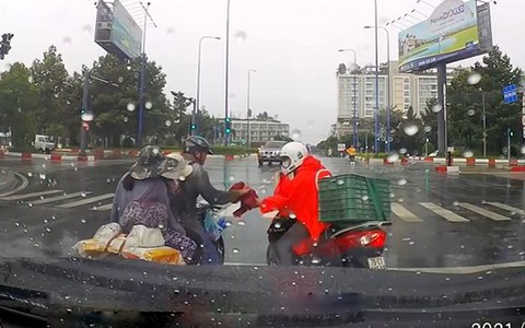 Chàng trai tặng áo mưa cho cặp vợ chồng chở con nhỏ ướt sũng