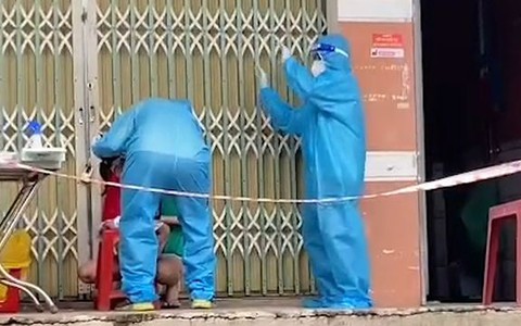 Nhân viên y tế nhảy múa mua vui cho bé khi lấy mẫu xét nghiệm