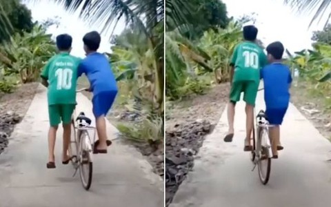 2 bé trai đi xe đạp nghệ thuật trên đường làng