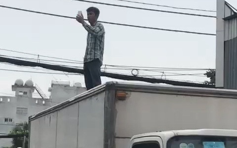 Một thanh niên cầm cây leo lên mui xe tải đòi 'uýnh' người qua lại