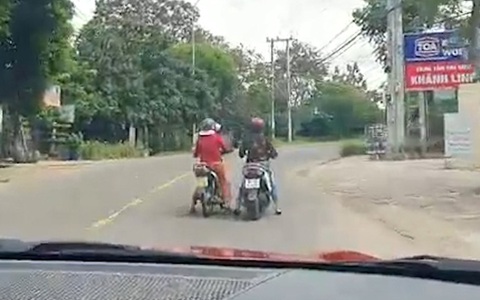 Hai người phụ nữ hồn nhiên dừng xe máy giữa đường buôn chuyện