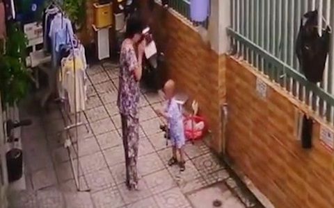 Bé trai bắt chước chắp tay lạy khi thấy bà thắp hương
