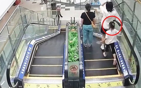 Chàng trai nhanh trí cứu bé gái kẹt chân vào thang cuốn