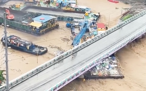 Nhiều sà lan bị nước cuốn vào cầu, hàng chục người được giải cứu