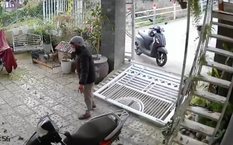 Người đàn ông chạy xe máy ôm cua tông sập cổng nhà dân