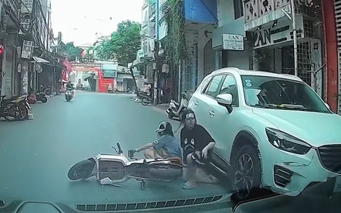 Cô gái vừa chạy xe đạp vừa lướt điện thoại tông vào ô tô