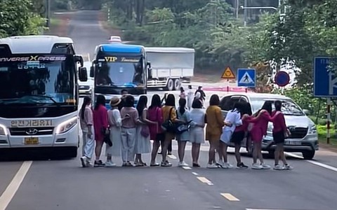 Hướng dẫn viên cho khách dàn hàng ngang chụp ảnh trên đường tại Măng Đen
