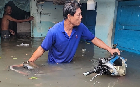Người dân lội nước đẩy xe máy ngập lút yên ra khỏi nhà ở Thủ Đức