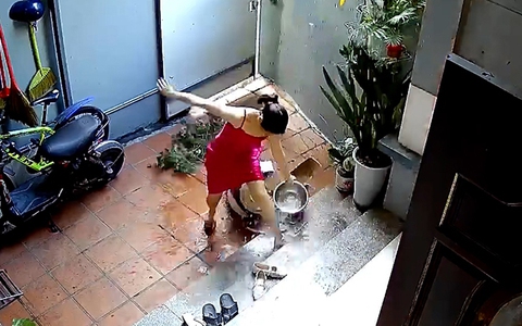 Người phụ nữ hú hồn khi bám tường tưới cây