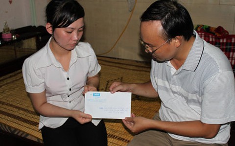 Trao tiền của bạn đọc Tuổi Trẻ cho cháu Vũ Quốc Linh