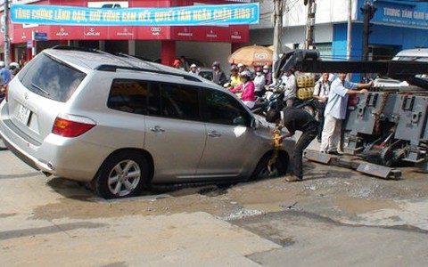 Xe du lịch sập hố giữa ngã tư