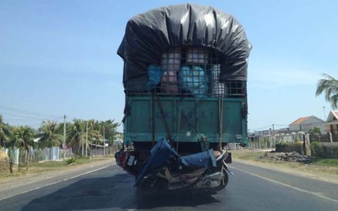 Vận tải đáng sợ: xe máy lủng lẳng bên hông xe tải