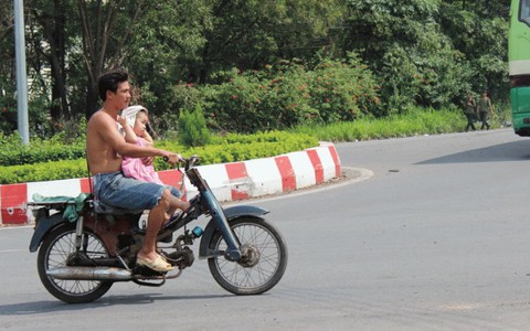 Cởi trần, chở con không mũ bảo hiểm vô tư trên phố