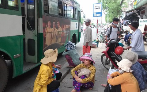 Đội nắng mưa chờ xe buýt
