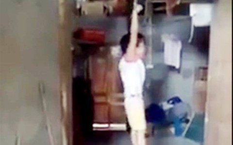 Mẹ nuôi cột tay bé gái treo lơ lửng xà nhà