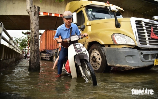 Ho Chi Minh City residents wade through flooded streets at rush hour as high tide hits again