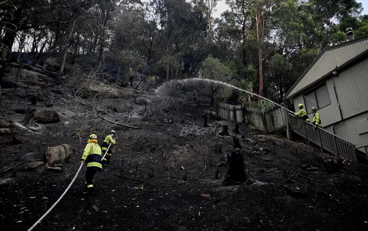Australian bushfires raze homes in two states; firefighter dies