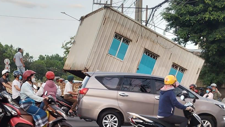 Video: Nhà container tái chế chở trên xe bị vướng cáp viễn thông, rớt giữ ngã tư đông đúc người đi lại