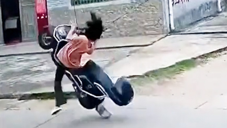 Vướng dây điện, cô gái và xe máy lộn ngược về phía sau