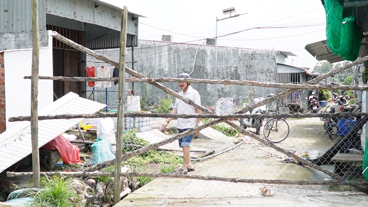 Một người dân đem cây rào đường mới xây dựng ở Cà Mau, vì sao?