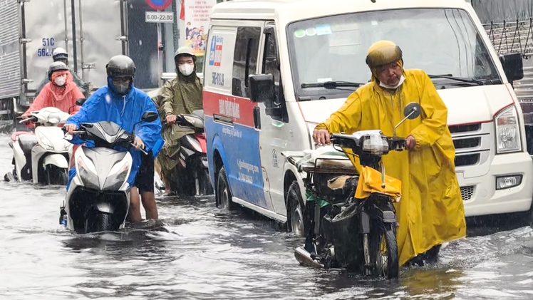 Mưa dầm ngày đầu tuần ở TP.HCM, nhiều người bì bõm dắt xe trên đường về nhà