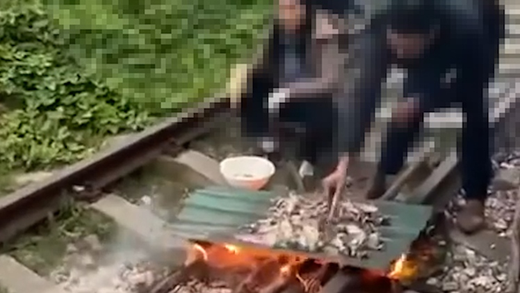 Cặp vợ chồng nướng đồ ăn trên đường ray bị lập biên bản xử phạt