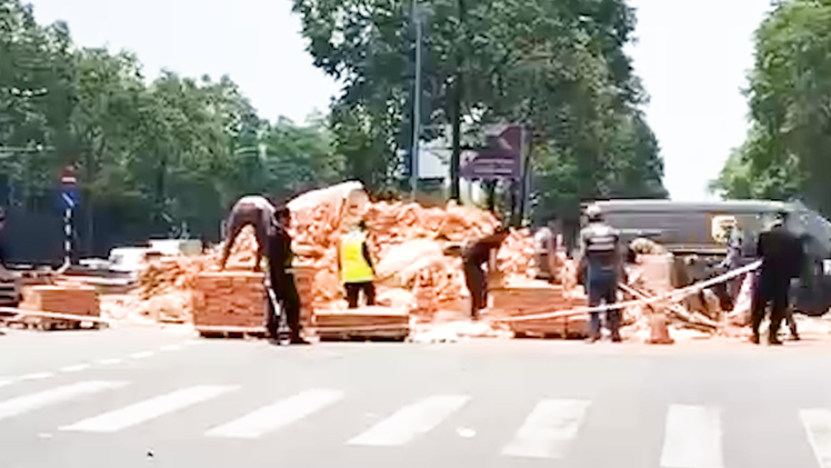 Xe container vào cua làm rơi hàng tấn gạch xuống đường ở TP.HCM