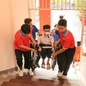 Gặp khó khăn khi đi lại, một sĩ tử được các tình nguyện viên nâng xe lăn lên cầu thang